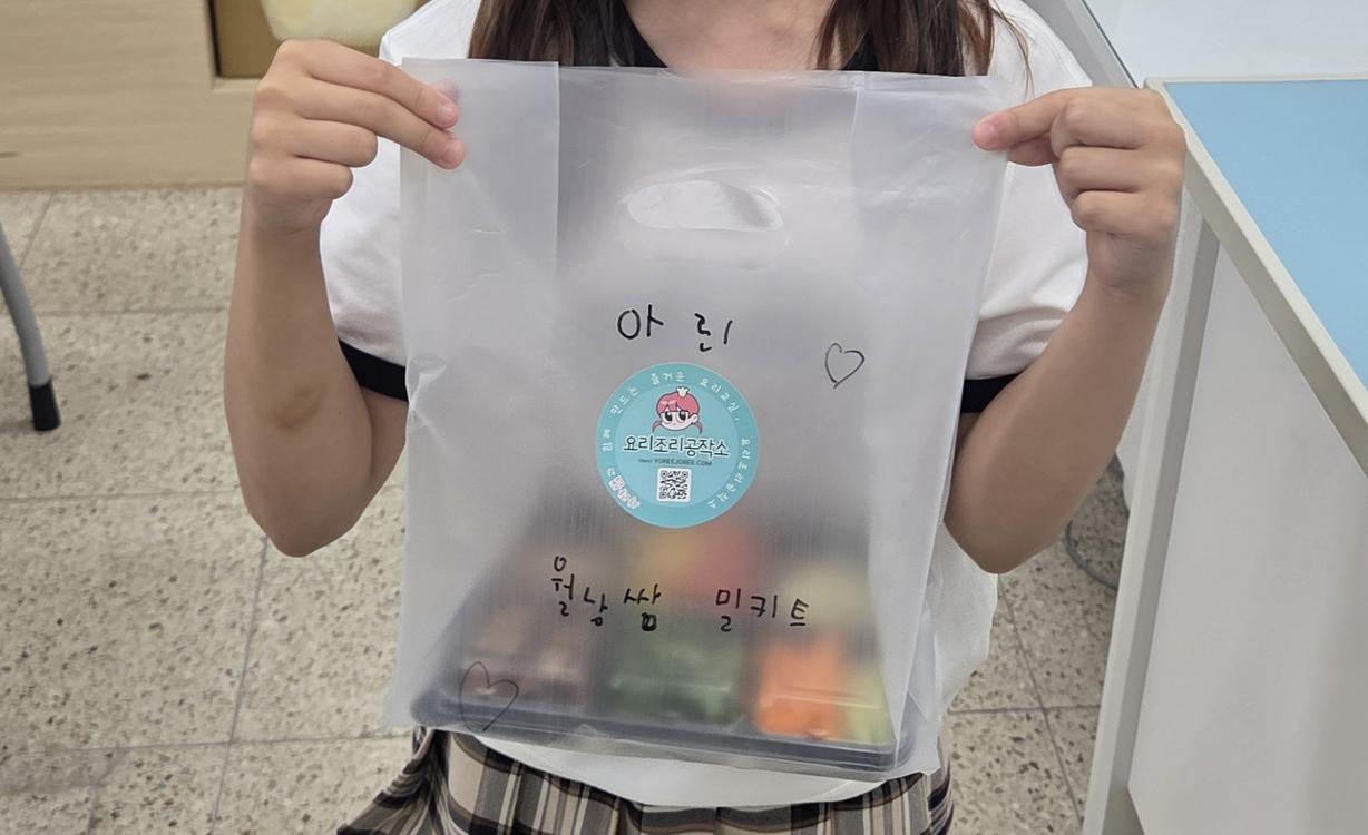 아린 학생이 직접 포장하고 이름까지 쓴 월남쌈 밀키트를 자랑스럽게 들어 보이고 있는 모습