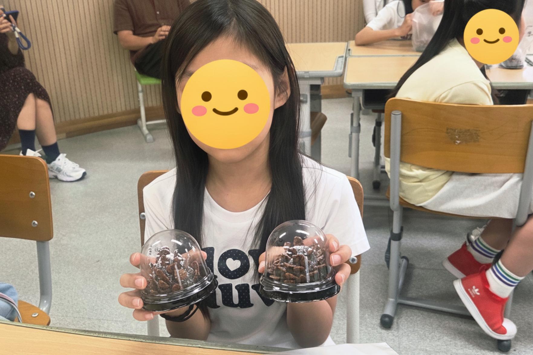 한 남자아이가 양손에 자신이 만든 두바이 솔방울 디저트를 들고 카메라를 응시하는 모습