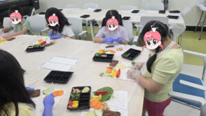 아이들이 고사리손으로 플라스틱 칼을 이용해 월남쌈 재료를 직접 썰고 있는 요리 수업 현장