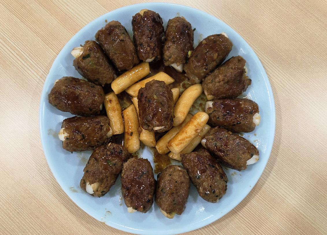 접시에 풍성하게 담긴 떡갈비 롤과 달콤짭짤한 양념이 배어든 떡꼬치 완성품